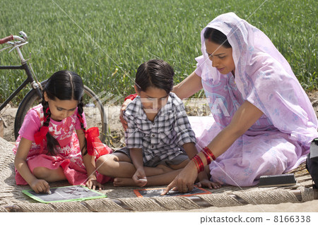 Mother helping daughter and son with their homework 8166338