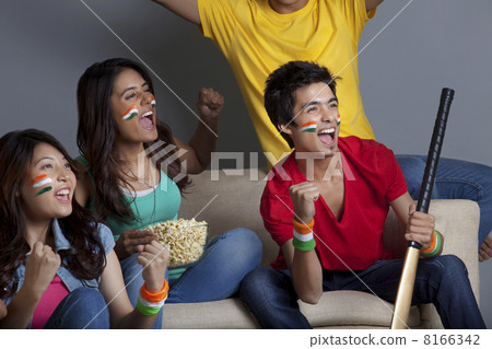 Happy young friends enjoying cricket match together at home Happy young friends enjoying cricket match together at home 8166342