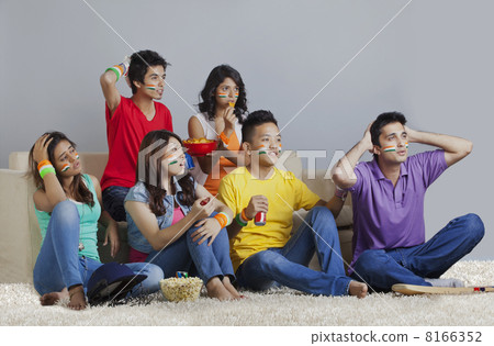 Young friends reacting with disappointment while watching cricket match Young friends reacting with disappointment while watching cricket match 8166352
