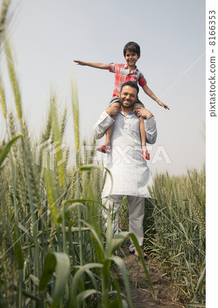 Low angle view of a happy father carrying son on shoulders 8166353