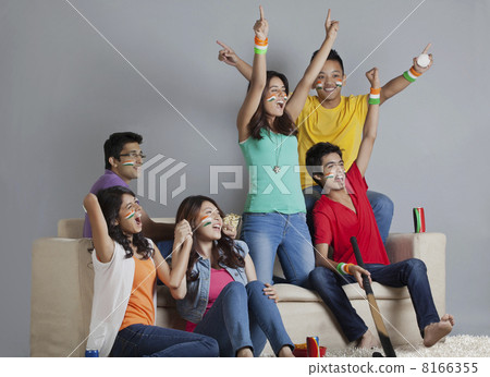Cheerful young friends having a great time together while watching hockey match at home Cheerful young friends having a great time together while watching hockey match at home 8166355