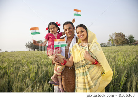 Portrait of a rural family holding an Indian flag 8166363