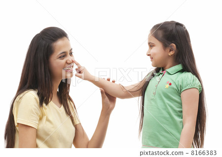 Cute little girl touching mothers nose over white background 8166383