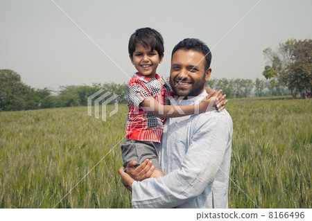 Portrait of a happy man carrying his son with wheat field in background 8166496