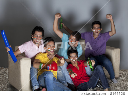 Happy young male friends enjoying a boxing match together at home 8166520