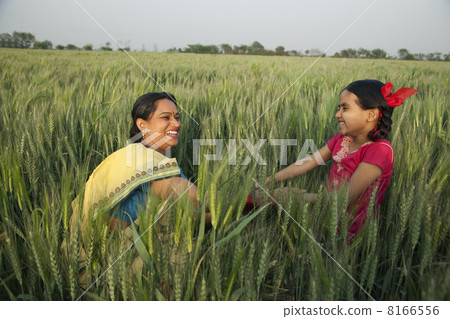 Cheerful mother and daughter playing in the wheat field 8166556