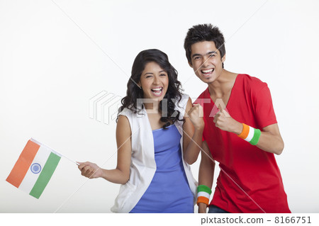 Portrait of happy young girl holding Indian flag while standing with friend over white background 8166751