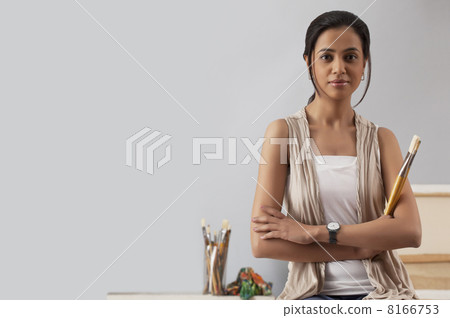 Portrait of a confident woman holding paintbrush 8166753