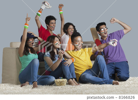 Happy young friends having a great time together while watching cricket match at home 8166826