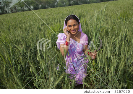 Portrait of a happy Indian female farm worker talking on cell phone Portrait of a happy Indian female farm worker talking on cell phone 8167020