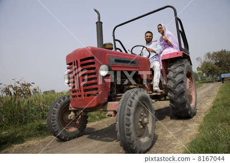 Low angle view of an Indian couple sitting in a tractor 8167044