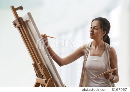 Young woman painting on canvas 8167067