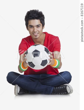 Portrait of young boy smiling while holding soccer ball over white background 8167119