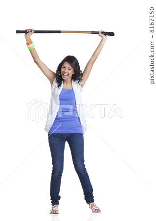 Full length portrait of happy young woman in casuals holding up hockey stick over white background 8167150