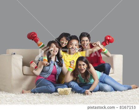 Portrait of happy young friends watching a boxing match together at home Portrait of happy young friends watching a boxing match together at home 8167153