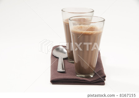 Glasses of chai and steel spoon kept on table napkin isolated over white background Glasses of chai and steel spoon kept on table napkin isolated over white background 8167155
