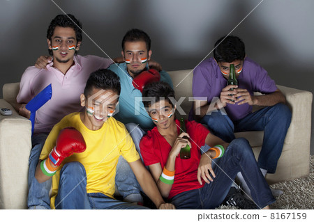Young male friends watching boxing match together at home 8167159