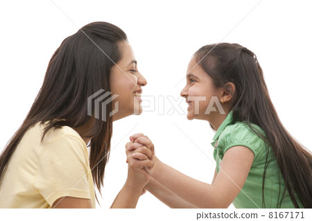Side view of cheerful mother and daughter holding hands over white background Side view of cheerful mother and daughter holding hands over white background 8167171