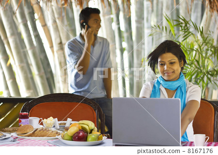 Woman sitting on breakfast table with laptop Woman sitting on breakfast table with laptop 8167176