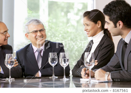 Young business professionals sitting with senior male executives in office 8167561