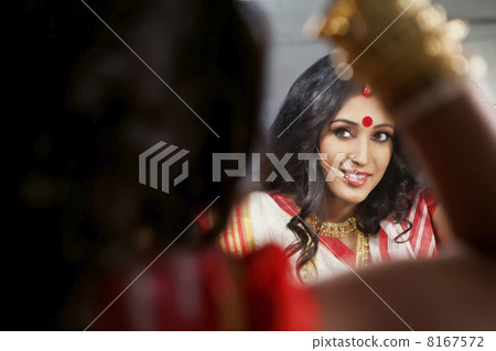 Bengali woman looking at herself in the mirror 8167572