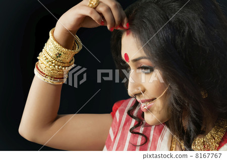 Bengali woman putting sindoor on her forehead Bengali woman putting sindoor on her forehead 8167767