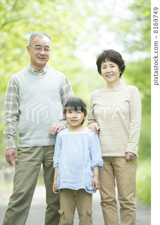 Grandparents and grandchildren smiling in fresh green 8169749