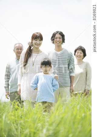 Three generations family smiling at the grassland 8169821