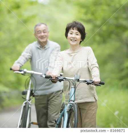 推擠一輛自行車以新綠色的資深夫婦 8169871