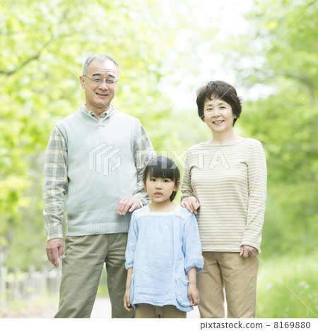Grandparents and grandchildren smiling in fresh green 8169880