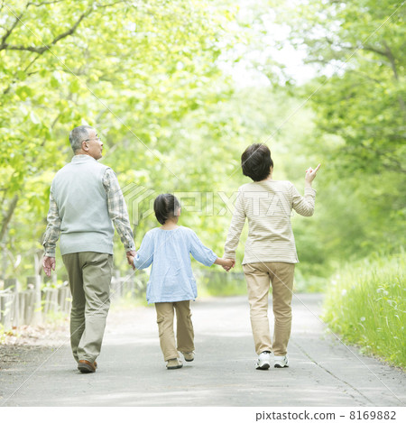 Grandparents holding hands in fresh green and grandchild's back 8169882
