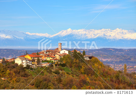 Small town on the hill and snowy mountains on background. 8171613