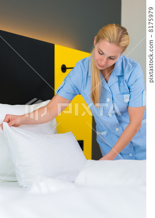 Service in hotel, maid puts clean sheets on bed Service in hotel, maid puts clean sheets on bed 8175979