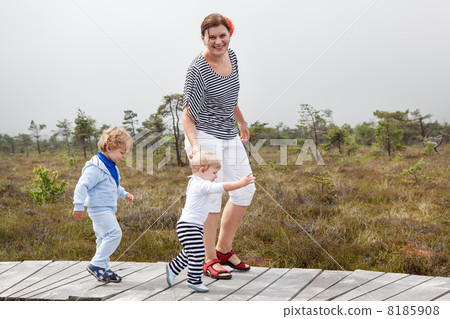 Young woman and two little toddler boys in nature park Young woman and two little toddler boys in nature park 8185908