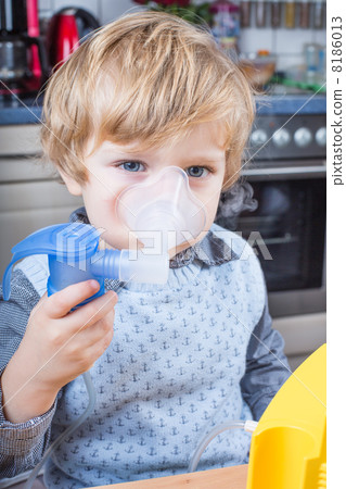 Little boy making inhalation with nebuliser 8186013