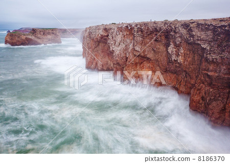 Small fishermen on a giant rock in a storm. 8186370