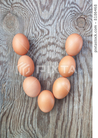 A letter v from the eggs for Easter. On a wooden texture. 8186468