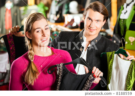 Young couple is buying Tracht or dirndl in a shop 8188559