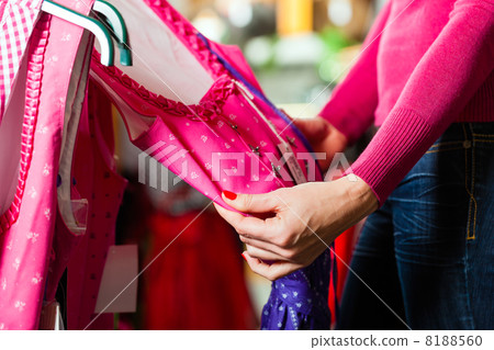 Woman is buying Tracht or dirndl in a shop 8188560