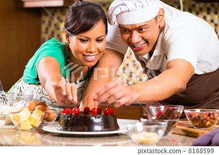 Asian couple baking chocolate cake in kitchen Asian couple baking chocolate cake in kitchen 8188599