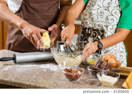 Asian couple baking cake in home kitchen 8188600