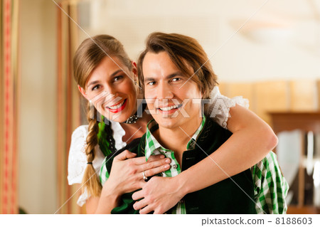Young couple in traditional Bavarian Tracht in restaurant or pub Young couple in traditional Bavarian Tracht in restaurant or pub 8188603