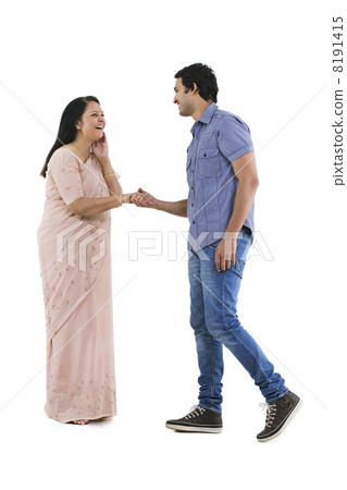 Smiling young man approaching his mother to dance 8191415