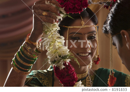 Maharashtrian bride and groom exchanging garlands in wedding 8191833