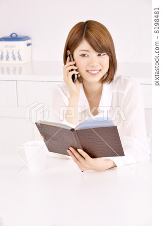 一個女人在看筆記本時打電話 一個女人在看筆記本時打電話 8198481