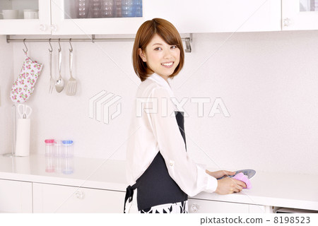 A woman wiping a dish in the kitchen A woman wiping a dish in the kitchen 8198523