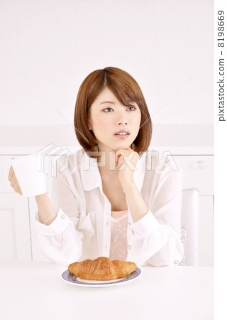 A woman eating a croissant A woman eating a croissant 8198669