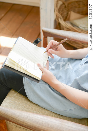 A woman writing in a notebook A woman writing in a notebook 8201597