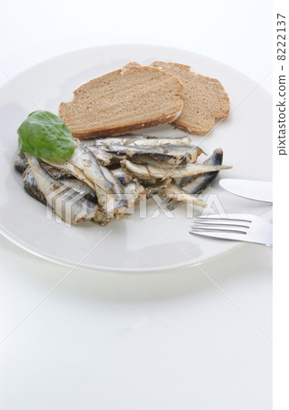 some sprats and bread on a white plate some sprats and bread on a white plate 8222137