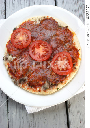 Salami pizza with tomato on a white plate Salami pizza with tomato on a white plate 8223971